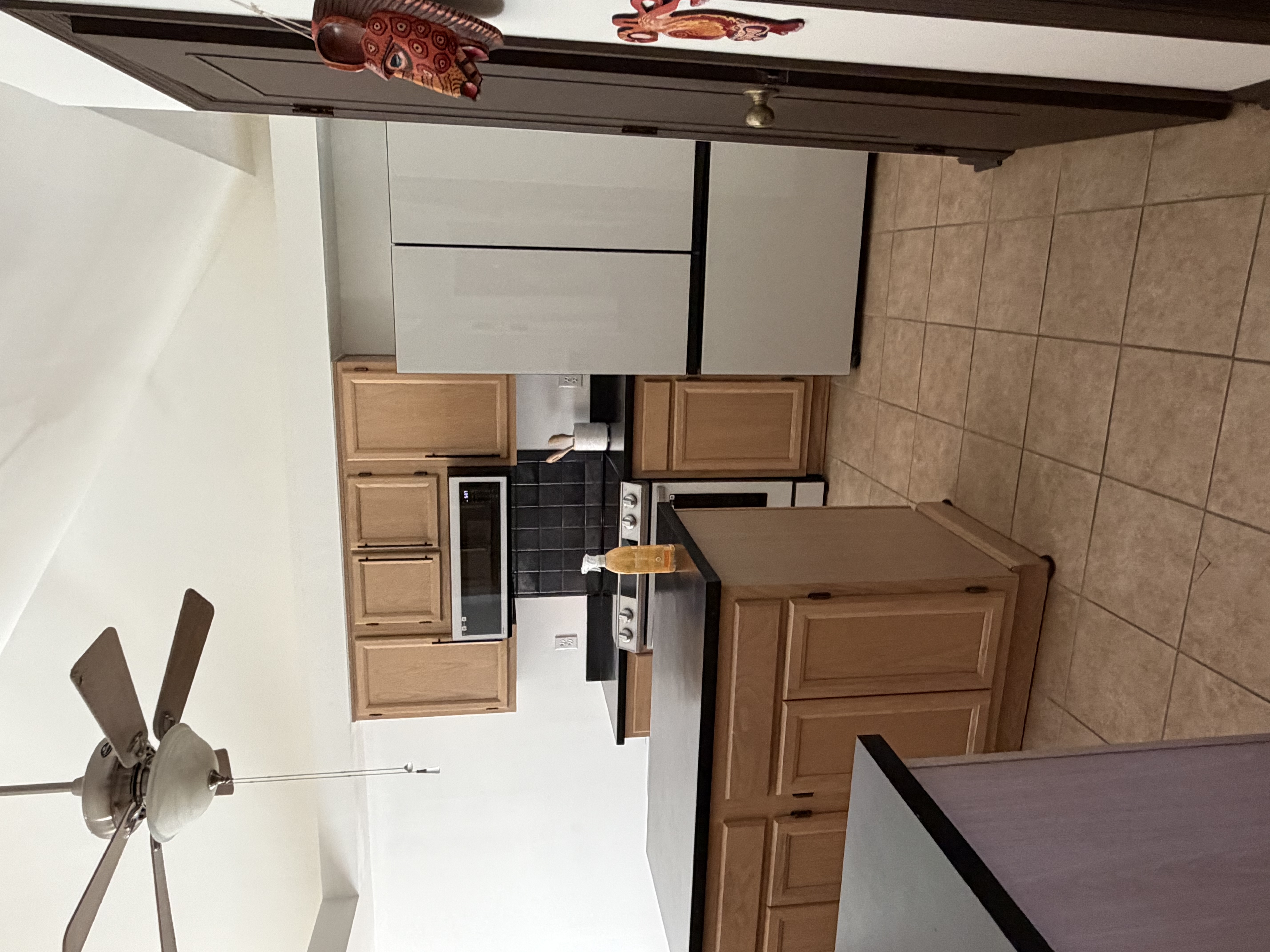 Kitchen with modern appliances, clean surfaces, and natural lighting