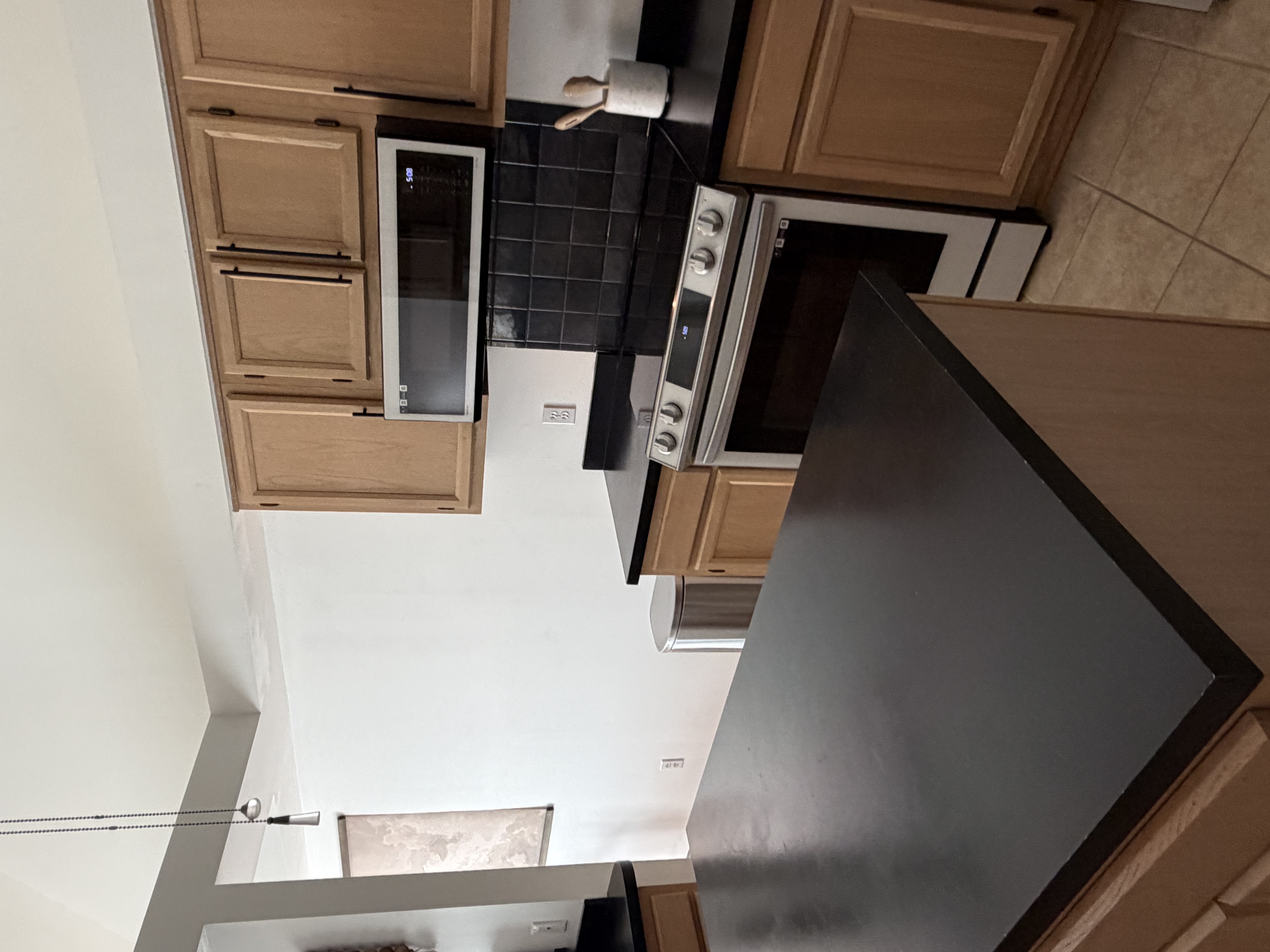 Kitchen with modern appliances, clean surfaces, and natural lighting