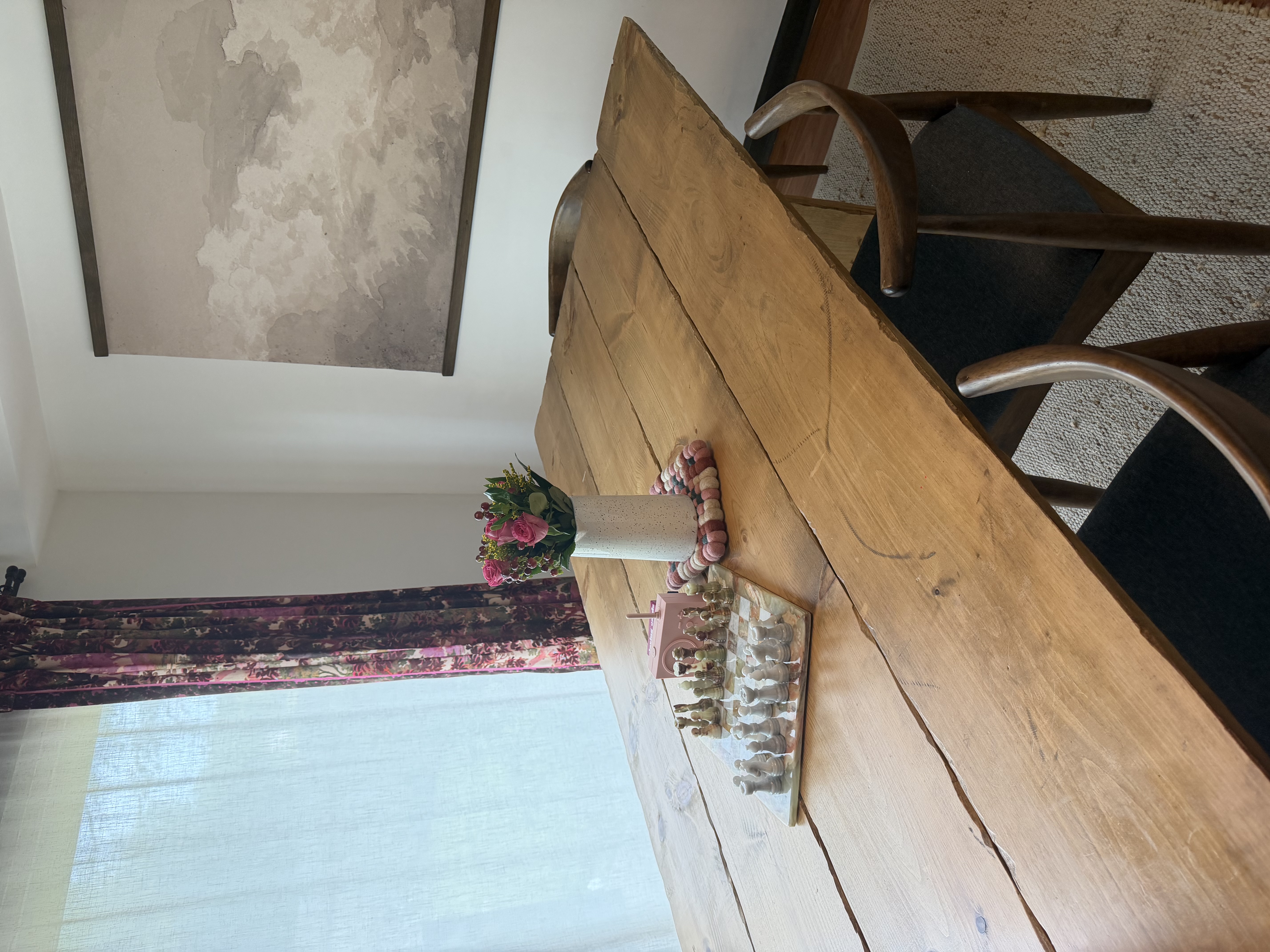 Dining area with a handmade wooden table for 6–8 and a solid marble chess board centerpiece